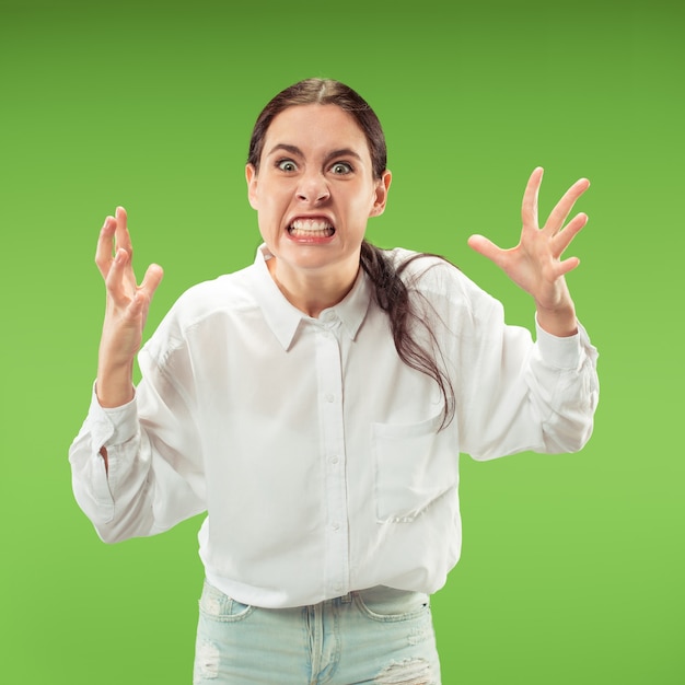 Portrait d'une femme en colère isolée sur un mur vert