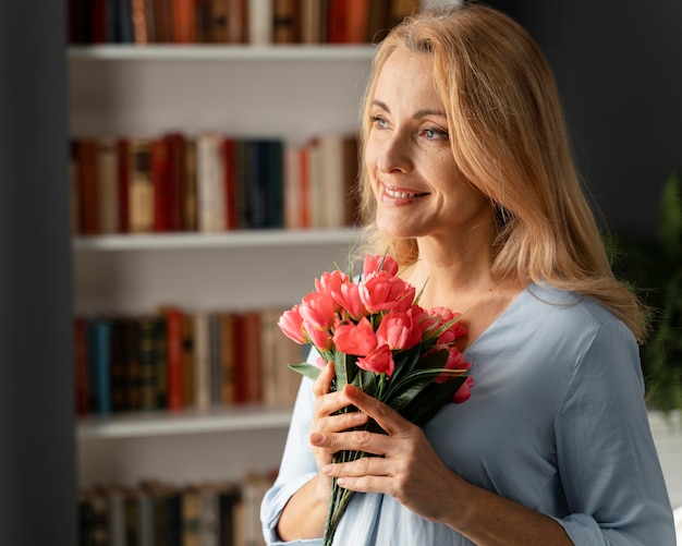 Photo gratuite portrait de femme conseillère tenant bouquet de fleurs