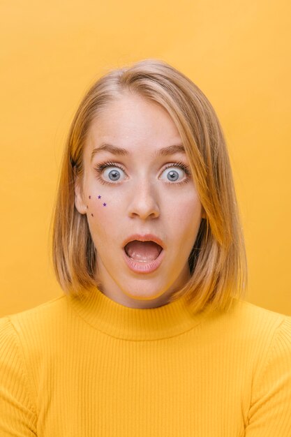 Portrait de femme avec différentes expressions faciales dans une scène jaune