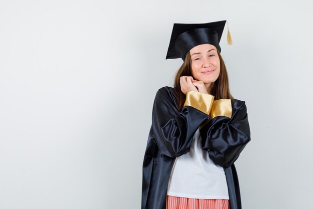 Portrait de femme diplômée posant avec les mains jointes dans des vêtements décontractés, uniforme et à la gracieuse vue de face