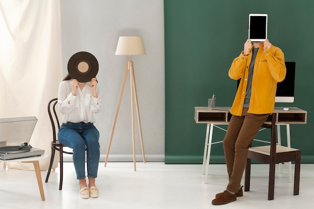 Portrait femme écoute de la musique à ramasser et homme à l'aide de tablette