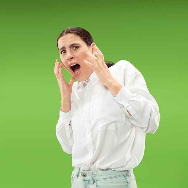 Portrait de la femme effrayée sur vert