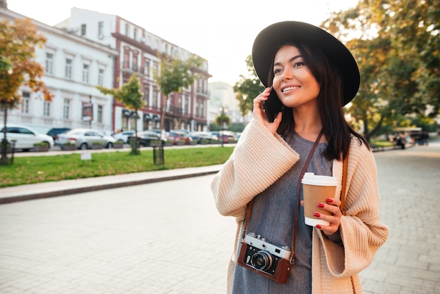 Portrait d'une femme élégante joyeuse tenant une tasse de café