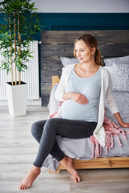 Portrait de femme enceinte au repos dans la chambre