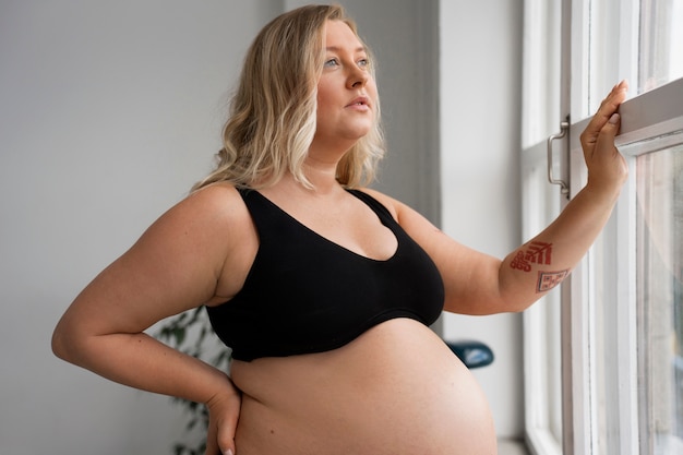 Photo gratuite portrait d'une femme enceinte de taille plus grande