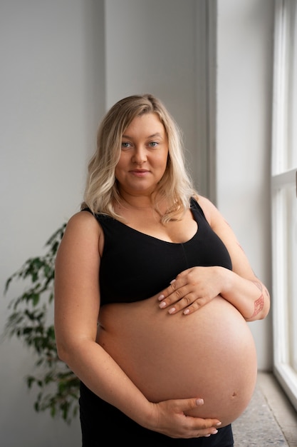 Photo gratuite portrait d'une femme enceinte de taille plus grande