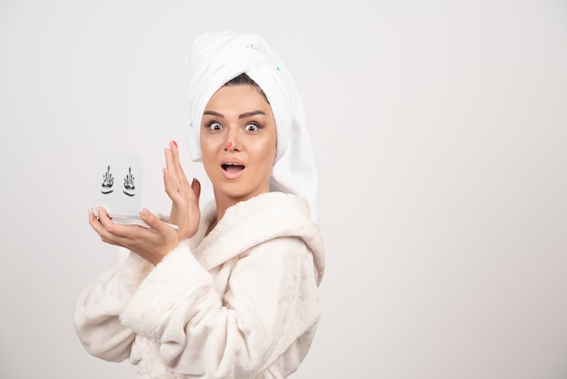 Portrait de femme enveloppée dans une serviette blanche avec palette d'ombres à paupières