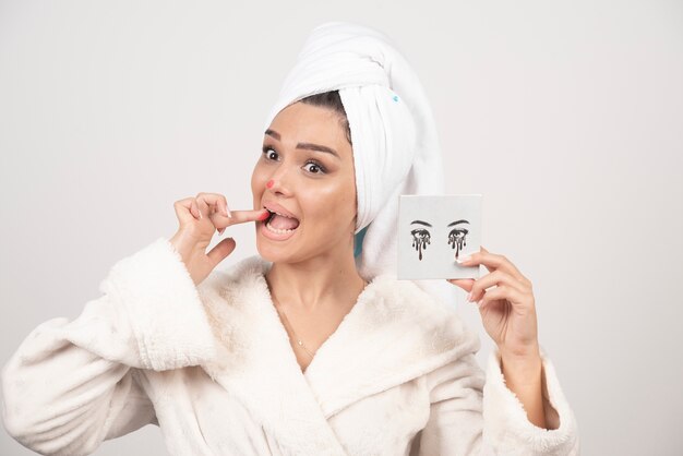 Portrait de femme enveloppée dans une serviette blanche avec palette d'ombres à paupières