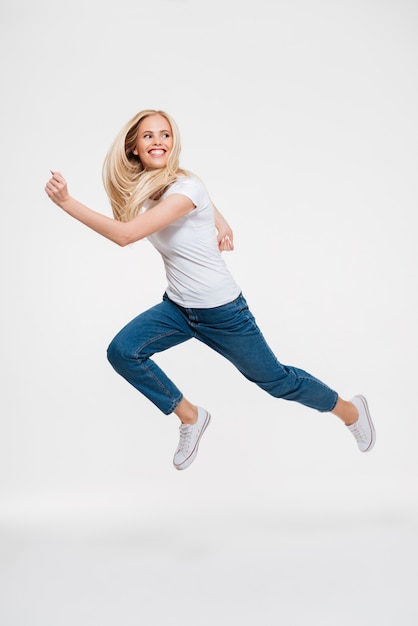 Portrait d'une femme excitée heureuse sautant