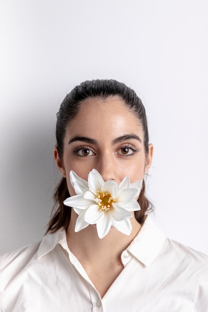 Portrait de femme avec fleur couvrant la bouche