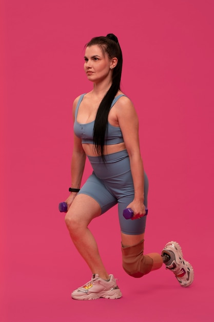 Photo gratuite portrait de femme handicapée avec jambe prothétique faisant de l'exercice avec des poids