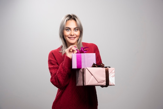Portrait de femme heureuse avec des coffrets cadeaux posant.