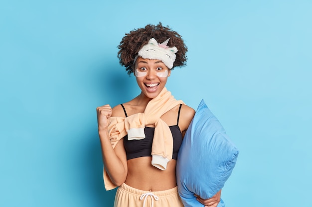 Portrait de femme heureuse à la peau sombre lève le poing célèbre quelque chose reste à la maison sur l'auto-isolement sourit largement