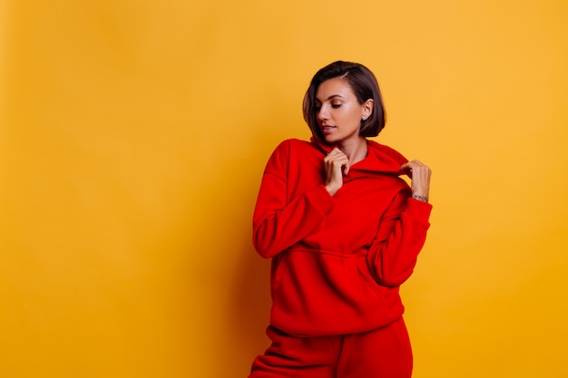 Portrait de femme heureuse portant un sweat à capuche et un pantalon en polaire rouge chaud à la mode, se préparant pour l'hiver froid