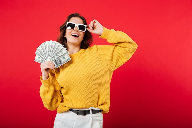 Portrait d'une femme heureuse en posant des lunettes de soleil