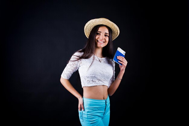 Portrait d'une femme heureuse posant avec passeport et chapeau