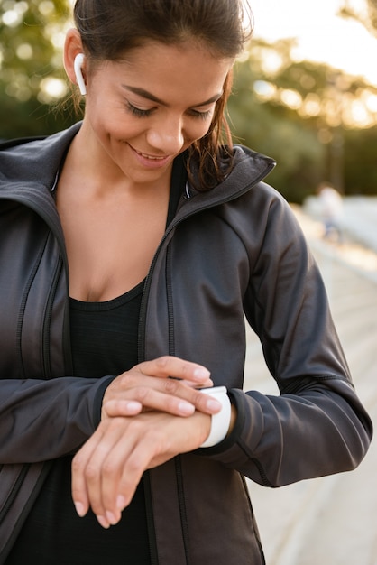 Portrait d'une femme heureuse de remise en forme dans les écouteurs