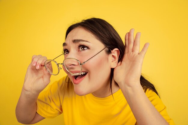 Portrait de femme isolé sur mur jaune studio