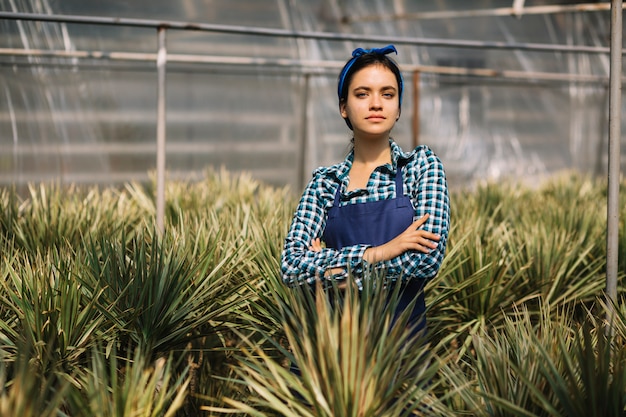 Photo gratuite portrait d'une femme jardinier entourée de plantes en serre