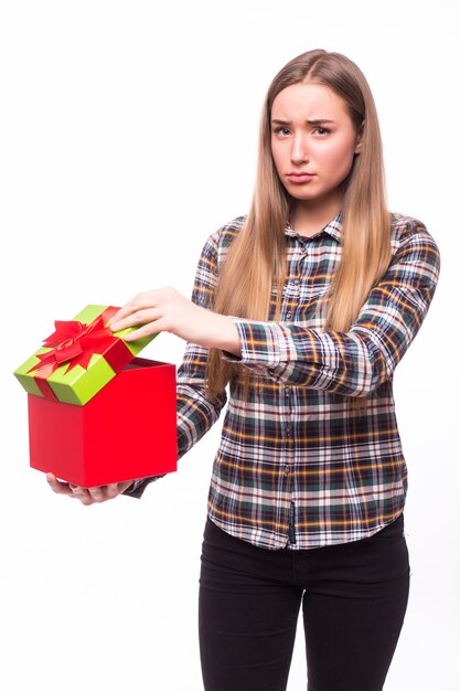 Portrait d'une femme joyeuse ouverture boîte-cadeau isolé sur un mur blanc