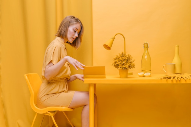 Photo gratuite portrait de femme lisant dans une scène jaune