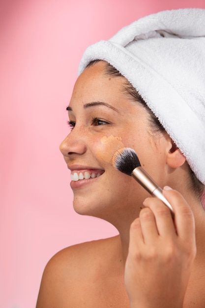 Photo gratuite portrait d'une femme magnifique à l'aide d'un pinceau de maquillage