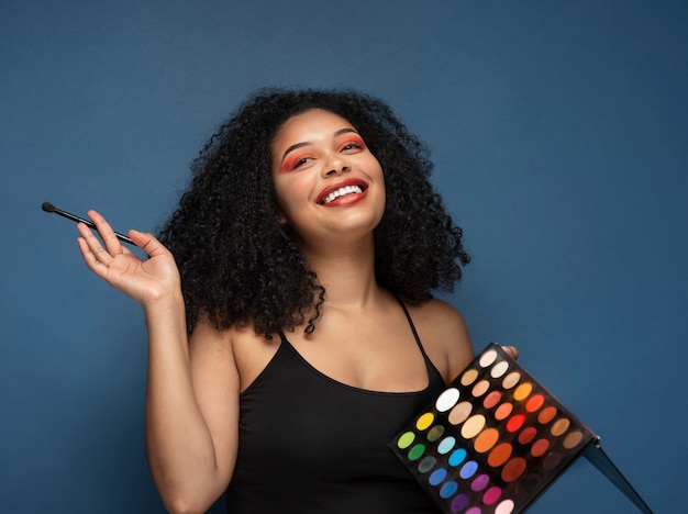 Photo gratuite portrait d'une femme magnifique tenant une palette de fard à paupières