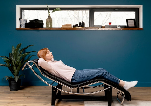 Portrait femme à la maison de détente sur une chaise