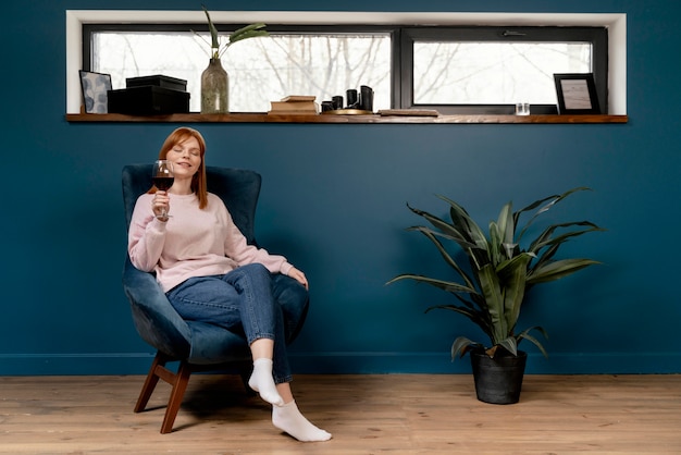 Portrait femme à la maison de détente sur une chaise