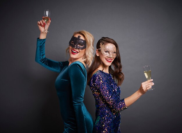 Portrait de femme avec des masques et du champagne à la fête