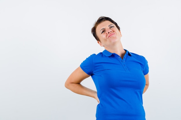 Photo gratuite portrait de femme mature souffrant de maux de dos en t-shirt bleu et à la vue de face inconfortable