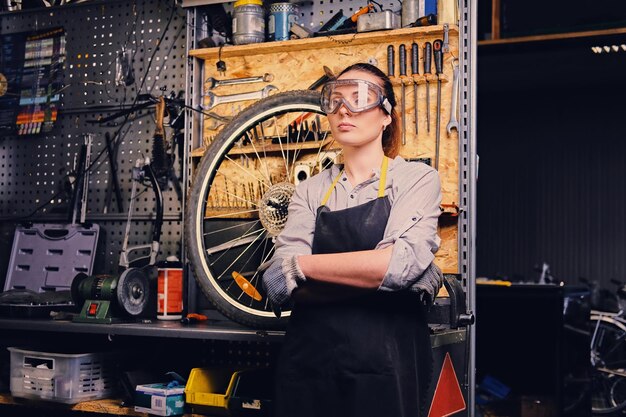 Portrait de femme mécanicienne de vélo sur fond de support d'outil.