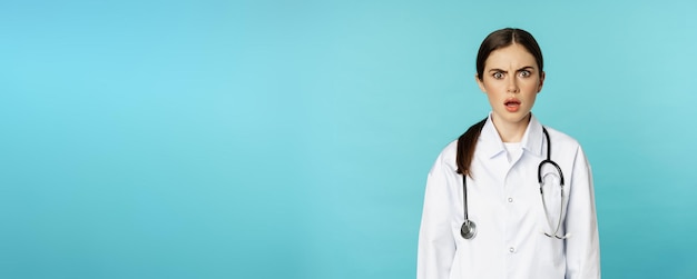 Photo gratuite portrait d'une femme médecin choquée stagiaire à l'hôpital en blouse blanche semblant inquiète et confuse