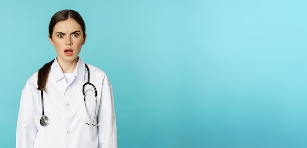 Photo gratuite portrait d'une femme médecin choquée stagiaire à l'hôpital en blouse blanche semblant inquiète et confuse