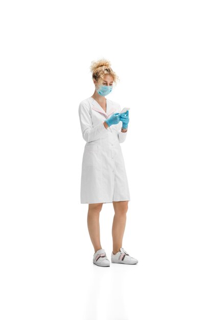 Portrait de femme médecin infirmière ou cosmétologue en uniforme blanc et gants bleus sur blanc