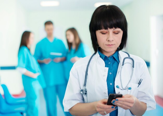 Portrait de femme médecin avec des stagiaires en arrière-plan