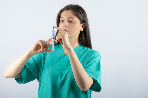 Portrait de femme médecin tenant une grosse seringue. .