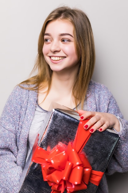 Photo gratuite portrait d'une femme mignonne souriante ouvrant une boîte-cadeau