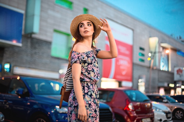 Le portrait de femme de mode de jeune fille assez branchée posant dans la ville en Europe