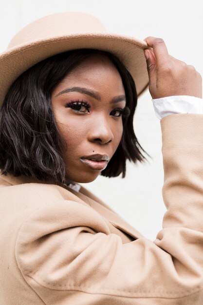 Portrait de femme à la mode tenant son chapeau