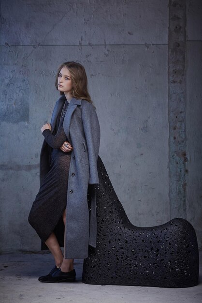 Portrait de femme moderne dans un manteau gris.