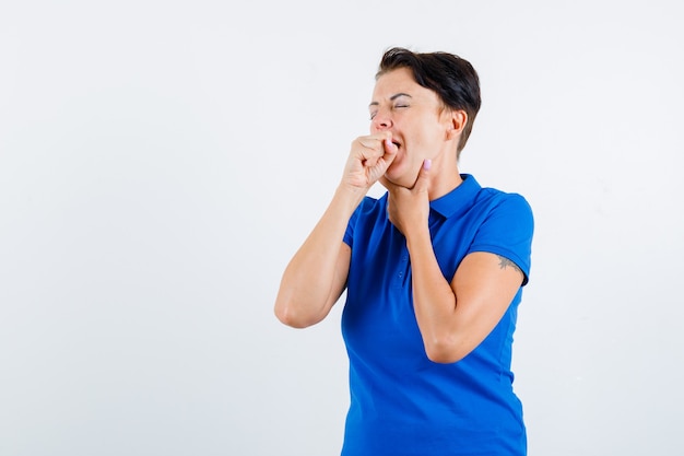 Portrait de femme mûre souffrant de toux en t-shirt bleu et à la vue de face malade