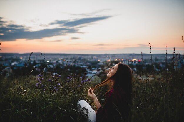 Portrait de femme, nature. Femme en chemise violette est assis sur l&#39;herbe