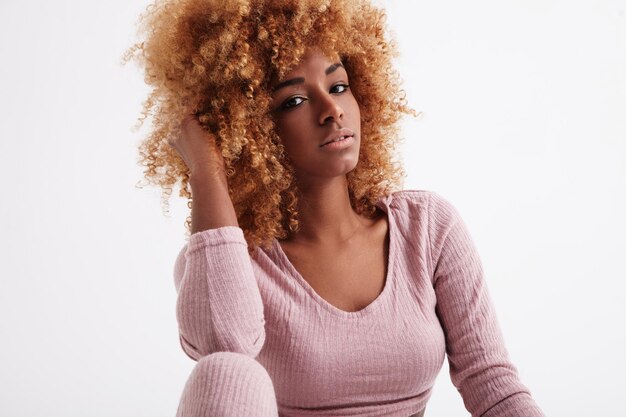Le portrait de la femme noire touche ses cheveux afro