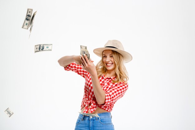 Portrait de femme pays jetant de l'argent sur blanc.