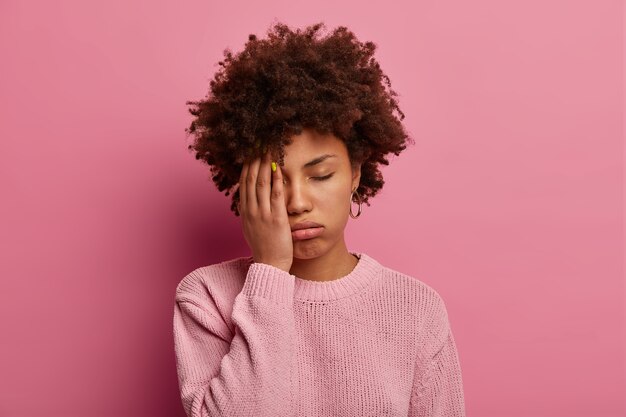 Portrait de femme à la peau foncée couvre la moitié du visage, soupire de fatigue