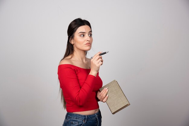 Portrait d'une femme pensive tenant un livre.