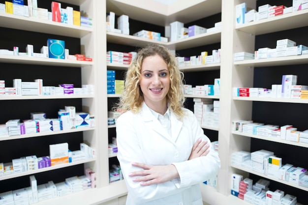 Photo gratuite portrait de femme pharmacien en pharmacie debout devant des étagères avec des médicaments