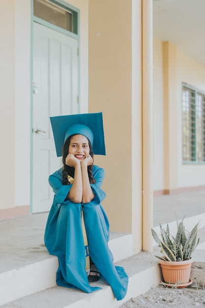 Photo gratuite portrait d'une femme philippine portant sa casquette, sa robe et sa ceinture de remise des diplômes.