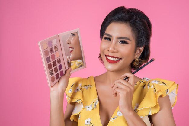 Portrait de femme avec pinceau de maquillage et cosmétique